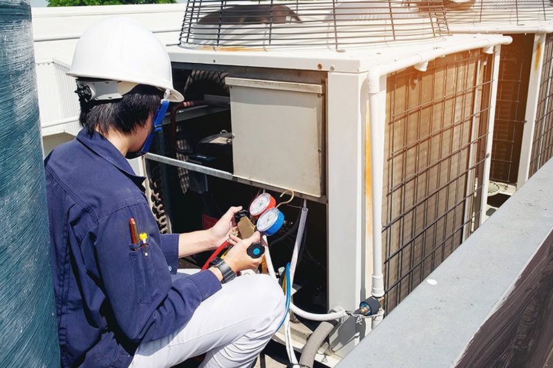 Why Is a Commercial AC Tune-Up Important? A technician working on a unit.