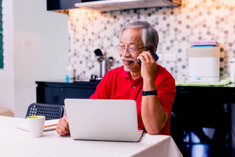 senior man working at home in his kitchen.
