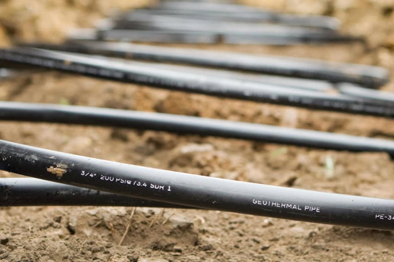 Workers Laying Geothermal Coils in an Underground Trench